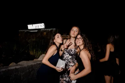 Tre ospiti in posa vicino al laghetto notturno, con il logo VANTES illuminato sullo sfondo. La scena è spontanea e festosa, con l'acqua e la vegetazione che incorniciano il momento.