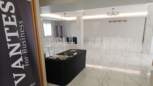 Sala per eventi aziendali con sedie disposte in file, tavolo relatori e banner VANTES visibili all'ingresso e sullo sfondo. L'ambiente è minimale, luminoso e adatto a presentazioni o meeting.