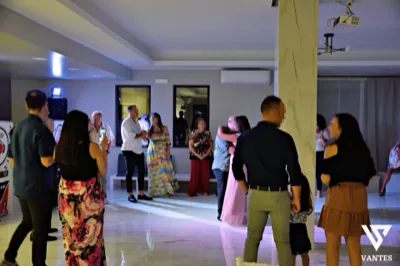 Ospiti raccolti nella sala durante un momento musicale o di intrattenimento, con luci soffuse e spazio libero adibito a pista. L'immagine restituisce l'atmosfera conviviale di una festa privata animata in interno.