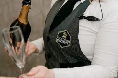 Team di Viglianisi Catering in divisa professionale che posa all'esterno della villa. Lo staff indossa abiti da lavoro eleganti e coordinati, trasmettendo ordine, professionalità e attenzione al servizio.